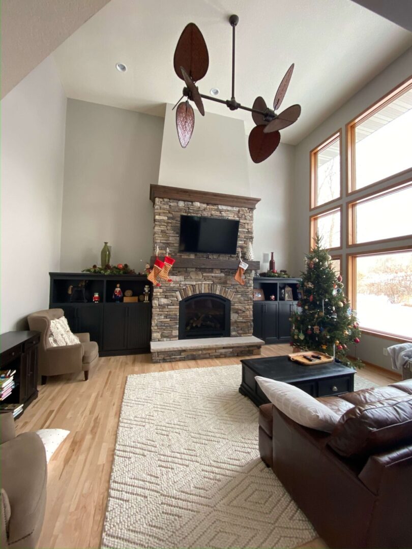 A living room with two fans and a fireplace.